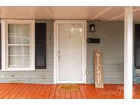 Cozy front door entrance with orange porch, welcome sign and white door at 1141 6Th St, Lancaster, SC 29720