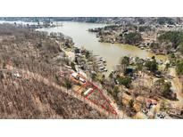 A stunning aerial view of a lakefront property highlighting its location and surrounding natural beauty at 144 Cherokee Ln, New London, NC 28127