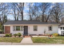 Charming single-story home featuring a white exterior, gray accents, and a welcoming brick pathway at 4820 Valley Stream Rd, Charlotte, NC 28209