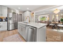 Bright, open-concept kitchen with stainless steel appliances and a view to the living and dining areas at 4820 Valley Stream Rd, Charlotte, NC 28209