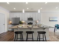 Bright eat-in kitchen with stainless steel appliances, light countertops and breakfast bar seating at 6450 Keeton Ln, Harrisburg, NC 28075