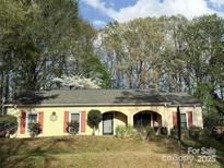 Charming single-story home features a well-manicured lawn and mature trees at 6721 Old Post Rd, Charlotte, NC 28212