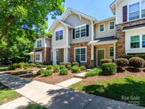 Charming townhome with stone accents, lush landscaping, and inviting entryway at 8009 Whitehawk Hill Rd, Waxhaw, NC 28173