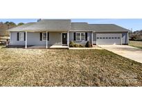 Charming home featuring a well-manicured lawn, covered porch, and attached garage, offering both curb appeal and practicality at 867 Meadow Hill Ct, Lincolnton, NC 28092
