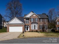 Charming two-story brick home with a well-manicured lawn and a two-car garage at 12729 Mcginnis Ln, Huntersville, NC 28078