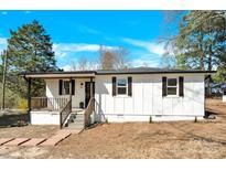 Charming single-story home with a white exterior, dark shutters, and a welcoming front porch with stone steps at 188 Bailey Rd, Mooresville, NC 28117