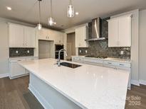 Bright kitchen featuring a large quartz island, stainless steel appliances, and stylish pendant lighting at 211 Halemarg Dr, Belmont, NC 28012