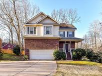 Charming two-story home featuring a brick facade, attached two-car garage and manicured front yard at 2553 Willowbrook Dr, Matthews, NC 28104