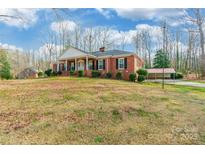 Classic brick home featuring a wide porch with stately columns and a well-manicured lawn at 406 Forest Dr, York, SC 29745
