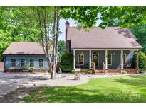 Charming home with a welcoming front porch, a well-maintained lawn, and a detached garage at 6688 Pine Forest Dr, York, SC 29745