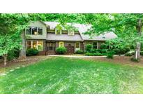 Charming brick home with lush landscaping and mature trees in a serene, wooded setting, offering a welcoming curb appeal at 1080 Rolling Green Dr, Newton, NC 28658