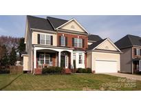 Charming two-story home featuring brick facade, black shutters, manicured lawn, and an attached two-car garage at 10845 Hellebore Rd, Charlotte, NC 28213