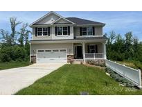 Charming two-story home features a two-car garage, covered front porch, and manicured lawn at 121 High Rock Ct # 08, Statesville, NC 28677