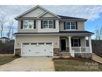 Charming two-story home featuring a two-car garage, stone accents, and a welcoming front porch at 121 High Rock Ct # 08, Statesville, NC 28677