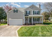 Charming two-story home with a cozy front porch, well-manicured lawn, and attached two-car garage at 13602 Red Wine Ct, Charlotte, NC 28273