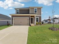 Charming two-story home features a two car garage and a well-maintained front yard at 150 Aberdeen Dr, Salisbury, NC 28144