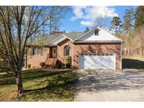 Charming brick home with attached two-car garage, manicured lawn, and inviting front entrance at 150 Hidden Oak Dr, Statesville, NC 28677