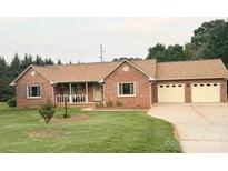 Charming red brick ranch home features a well-manicured lawn and a cozy covered front porch at 1922 Dogwood Flower Ln, Lincolnton, NC 28092