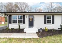 Charming brick home featuring a black front door with a decorative wreath and manicured landscaping at 2318 Knight Dr, Gastonia, NC 28052