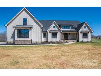 Stunning two-story modern farmhouse with white siding, black trim, and a well-manicured lawn at 2321 Ivey Church Rd, Maiden, NC 28650