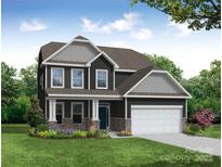 Charming two-story home with stone accents, white trim, a two-car garage, and a well-manicured lawn at 2789 Ashton Park Ln # 68, Monroe, NC 28110