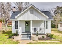 Charming front porch with white railings and an inviting green door adorned with a wreath at 357 Chestnut St, Rock Hill, SC 29730