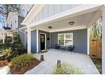 Inviting covered front porch with stylish seating area and freshly manicured plants at 4114 Rutgers Ave, Charlotte, NC 28206