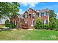 Charming two-story brick home with manicured lawn and lush landscaping at 6141 Abergele Ln, Matthews, NC 28104