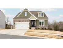 Charming two-story home with stone accents, a well-manicured lawn, and a two-car garage at 8828 Powder Works Dr, Huntersville, NC 28078
