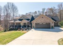 Stunning brick home with a welcoming front porch and spacious three-car garage on a sunny lot at 944 Clear Creek Cir, Lincolnton, NC 28092