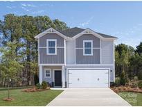 Charming two-story home features a two-car garage and landscaped front yard at 2106 Morgan Hills Dr, Albemarle, NC 28001