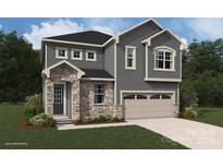 Charming two-story home with stone accents, gray siding, black door, and an attached two-car garage at 2639 Tillman St, Monroe, NC 28112