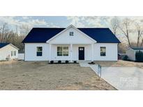 Charming home boasts a black front door, white siding, and a cozy front porch at 2725 Lyla Ave, Kannapolis, NC 28027