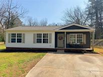 Charming single-story home featuring a welcoming front porch and a well-manicured lawn at 327 Berry St, Rock Hill, SC 29732