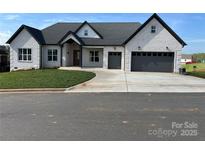 Charming single-story home featuring a two-car garage, classic white brick, and a lush green lawn at 4227 Holly Ne Cir, Conover, NC 28613