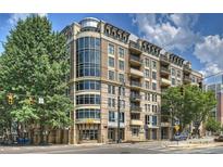 Contemporary multi-story condo building featuring large windows and balconies, with commercial spaces at street level at 718 W Trade St # 307, Charlotte, NC 28202
