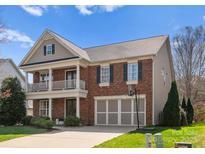 Charming two-story brick home featuring a balcony, two-car garage, and well-maintained front yard at 1016 Forbishire Dr, Matthews, NC 28104
