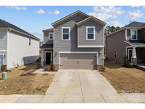 Charming gray two-story home featuring a two-car garage, landscaped yard, and inviting curb appeal at 2116 Belterra Dr, Charlotte, NC 28216