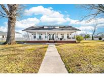 Charming white home featuring a spacious porch with swing and walkway to the front entrance at 308 W First St, Lowell, NC 28098