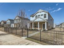 Charming two-story home with a well-manicured front yard and black metal fence at 428 Nixon Rd, Belmont, NC 28012