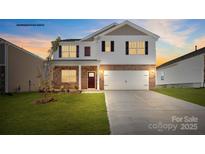 Two-story home boasts brick and siding accents, a well-manicured lawn, and a two-car garage at 469 Court House Ave, York, SC 29745