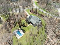 Beautiful aerial view of home surrounded by trees, with a pool and well-manicured lawn at 501 Colonels Ct, Clover, SC 29710