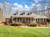 Charming brick home with a spacious front porch, dormer windows, and a well-manicured lawn at 501 Colonels Ct, Clover, SC 29710