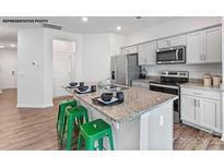 Modern kitchen features granite countertops, stainless steel appliances, and green barstools at the kitchen island at 537 Trading Post Ln, York, SC 29745