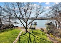 Scenic waterfront view with private docks and a well-manicured lawn leading to the water's edge at 6403 Amos Smith Rd, Charlotte, NC 28214