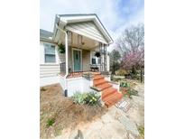 Welcoming covered front porch with brick steps and decorative metal railings, adding a touch of elegance to the home at 10633 Hwy 52 Hwy, Rockwell, NC 28138