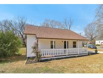 Charming home featuring a covered front porch, light colored siding, and a well-maintained lawn at 1156 9Th St, Lancaster, SC 29720