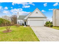 White home with a well-kept lawn, attached garage, and a charming entrance at 13705 Queenswater Ln, Charlotte, NC 28273