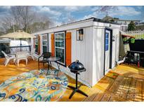 Charming home exterior featuring a patio with an umbrella, table, and grill for outdoor entertaining at 162 Dogwood Cir, New London, NC 28127