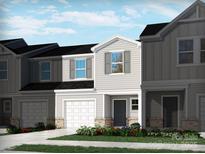 Charming new construction townhome featuring a two-car garage and beautifully landscaped front yard at 1734 Braemar Village Dr, Monroe, NC 28110